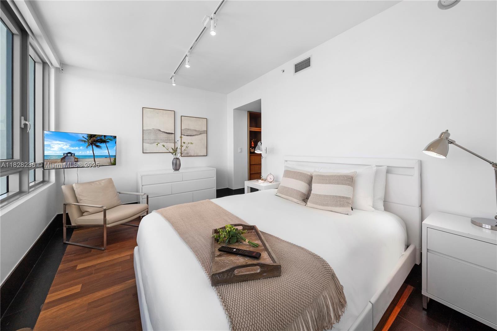 101 20th Street, Unit 3803 Miami Beach, FL 33139 - Photo 20 of 36 a bedroom with a bed and wooden floor