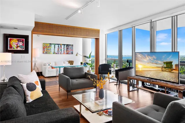 a living room with fireplace furniture and a large window
