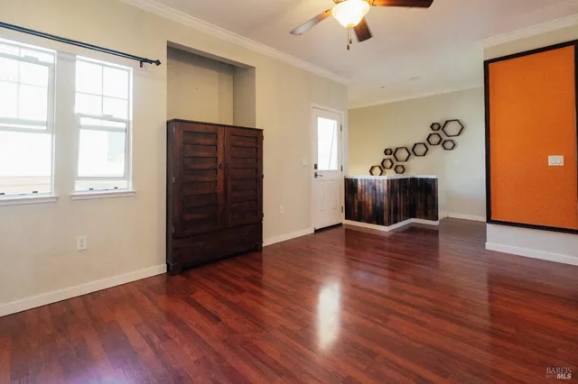 a view of a livingroom with wooden floor and a ceiling fan