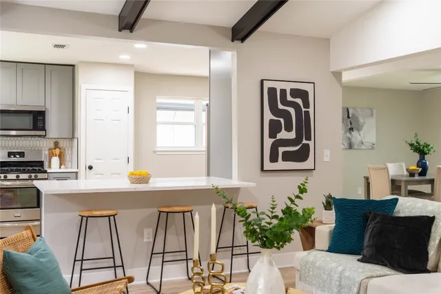 a kitchen with granite countertop a stove a sink and a wooden floors
