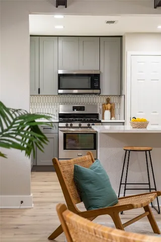 a kitchen with stainless steel appliances kitchen island granite countertop a sink and a white cabinets