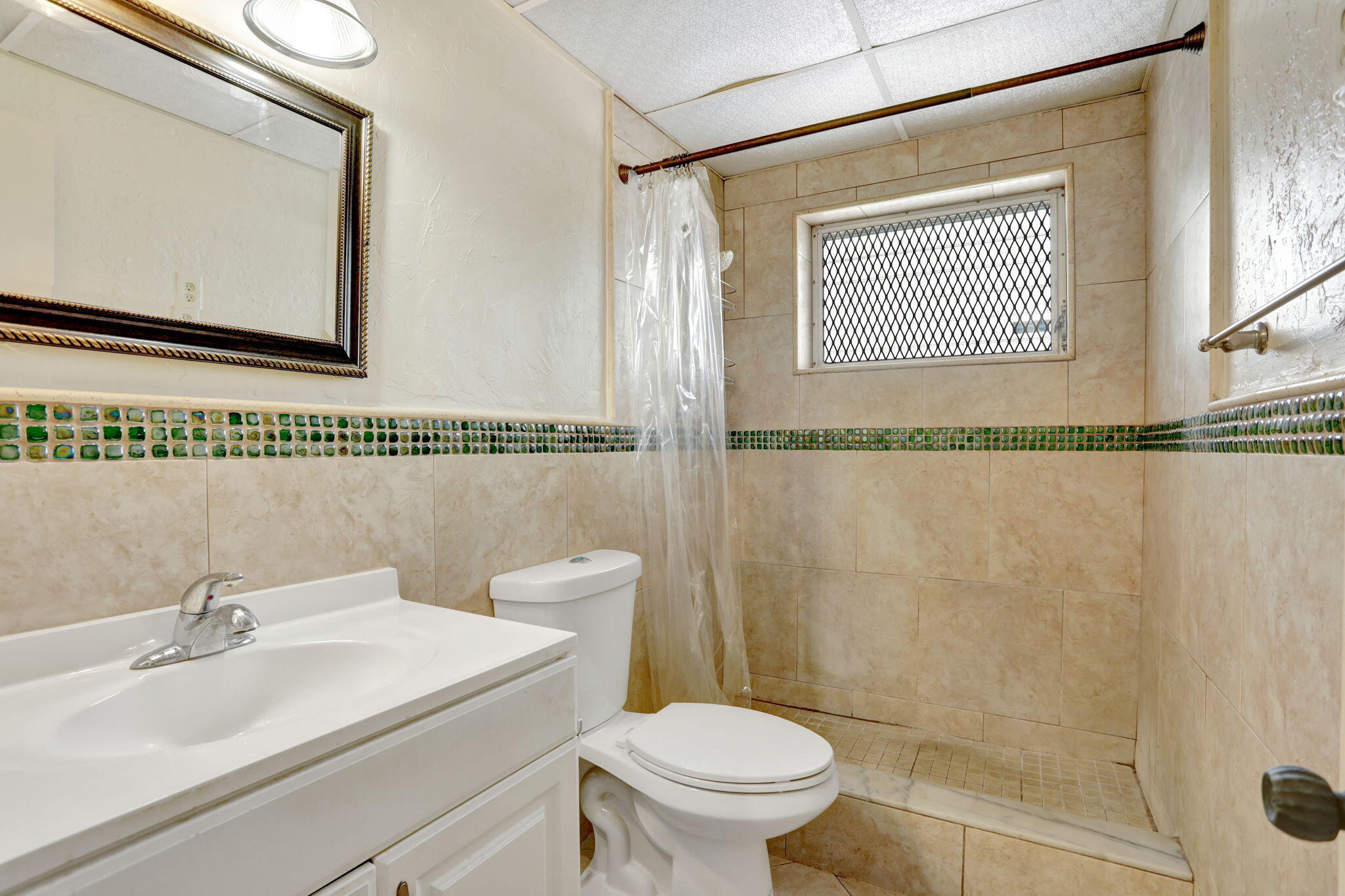 1021 Crystal Lake Drive, Unit 109 Deerfield Beach, FL 33064 - Photo 14 of 21 a bathroom with a sink a mirror and a toilet