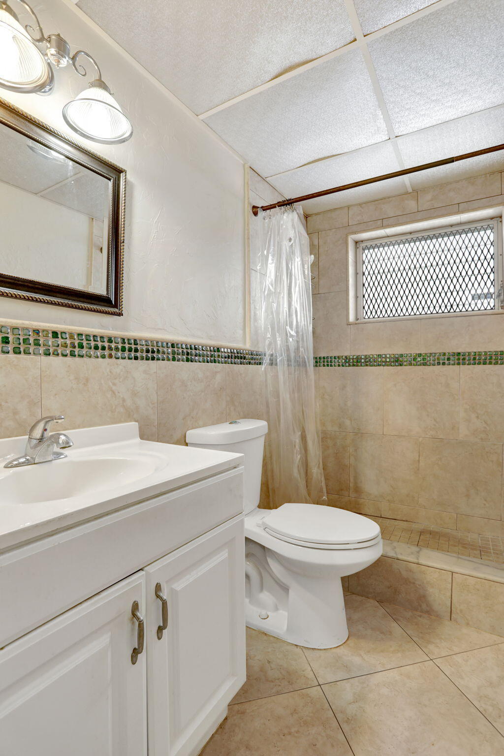 1021 Crystal Lake Drive, Unit 109 Deerfield Beach, FL 33064 - Photo 15 of 21 a bathroom with a sink a toilet and a mirror