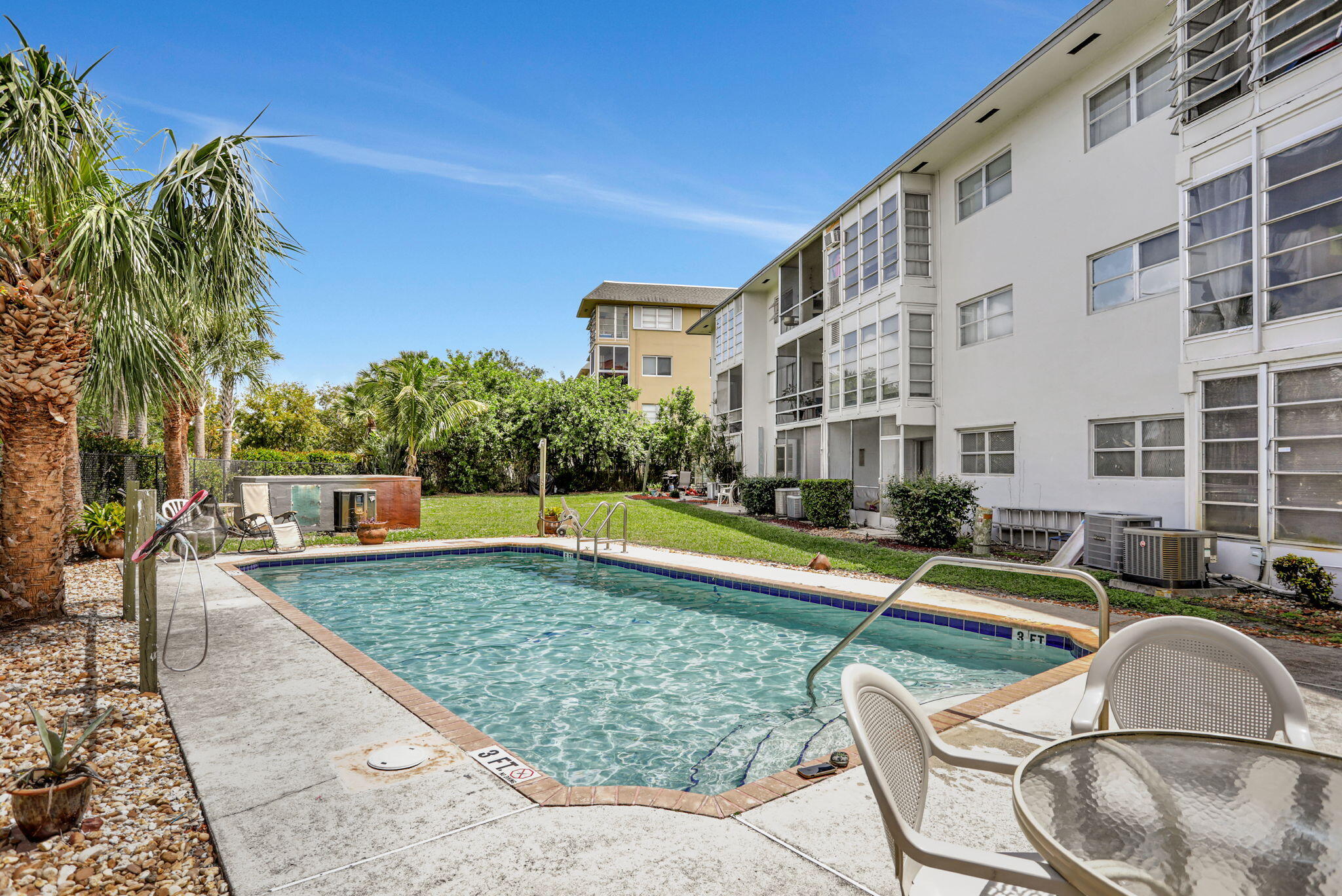 1021 Crystal Lake Drive, Unit 109 Deerfield Beach, FL 33064 - Photo 20 of 21 a view of a swimming pool with a lounge chair