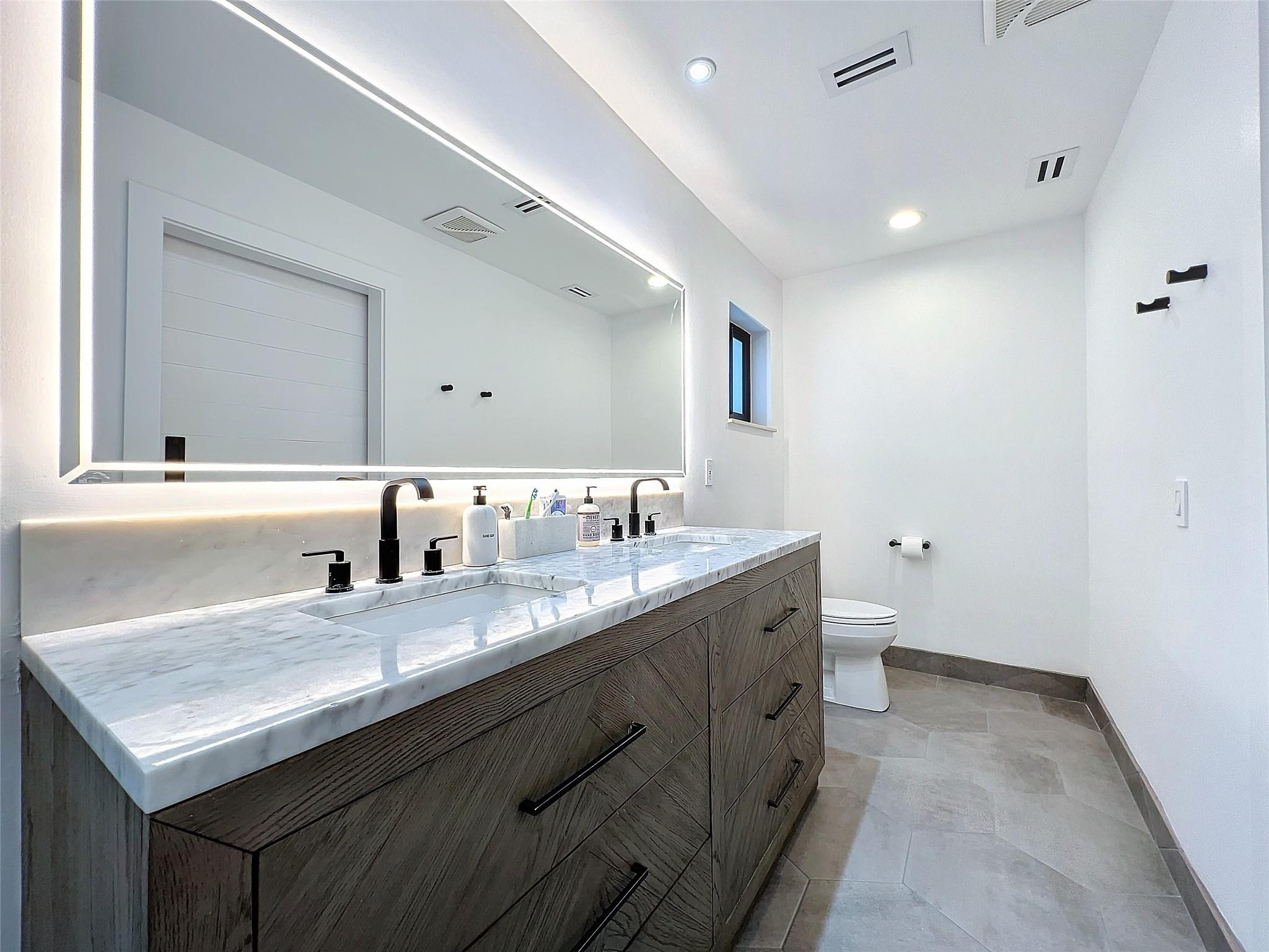 1501 Southwest 17th Street Boca Raton, FL 33486 - Photo 14 of 36 a bathroom with a granite countertop sink a toilet and a mirror