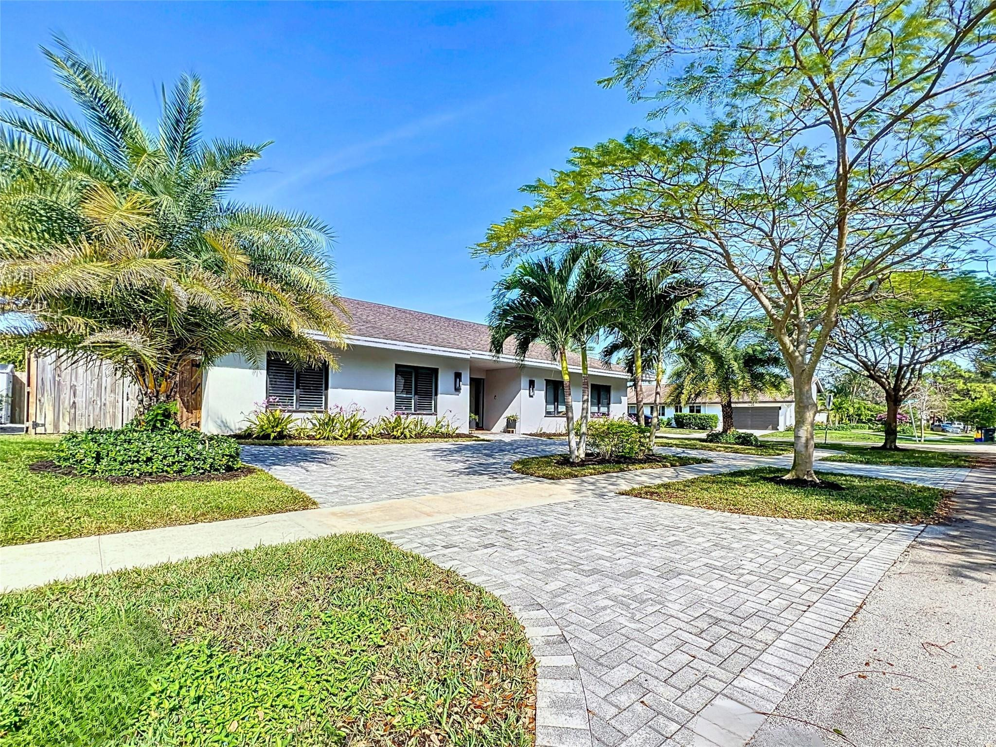 1501 Southwest 17th Street Boca Raton, FL 33486 - Photo 25 of 36 a front view of a house with a yard and potted plants
