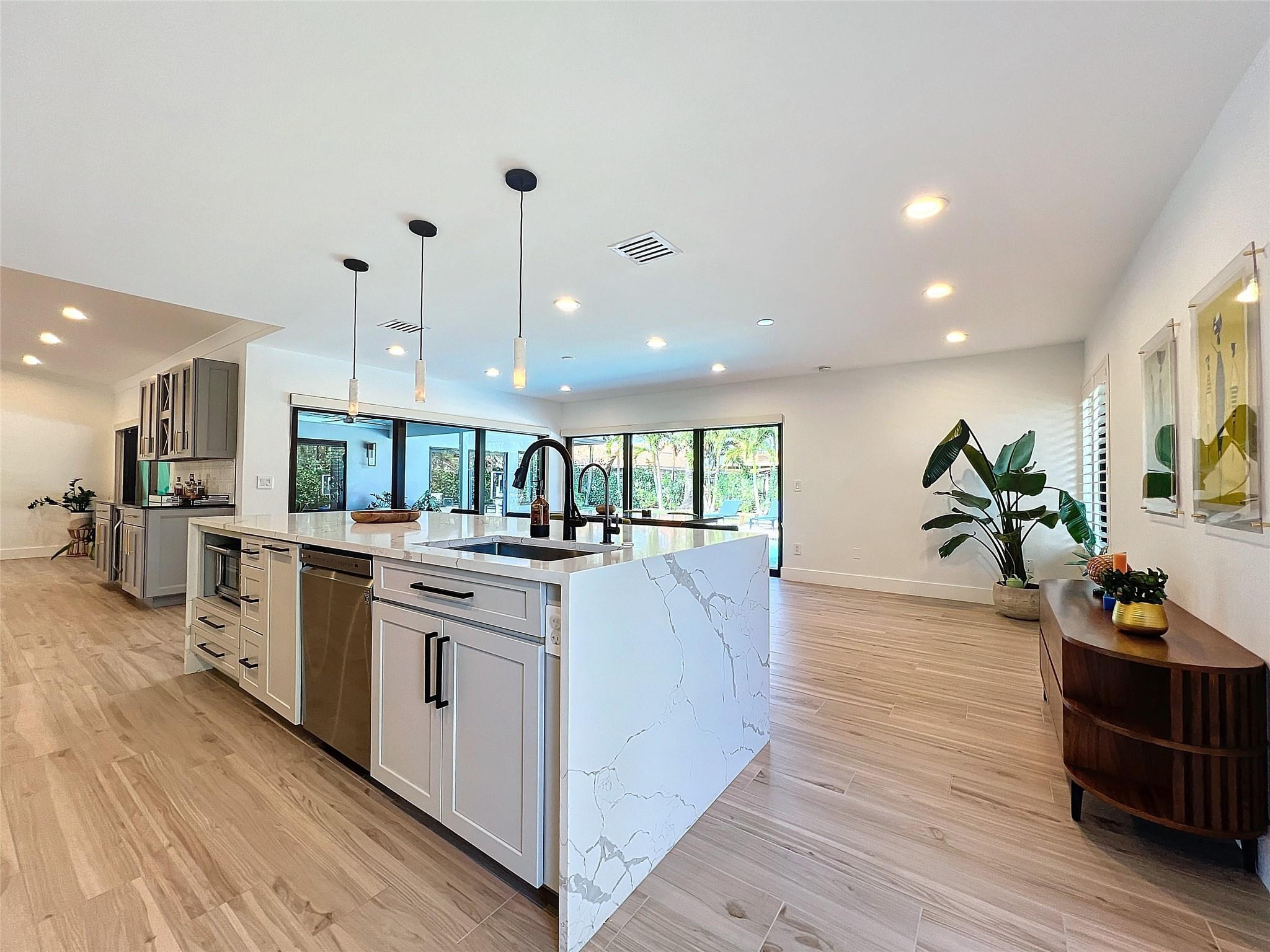 1501 Southwest 17th Street Boca Raton, FL 33486 - Photo 29 of 36 a large kitchen with stainless steel appliances kitchen island a large counter top and a wooden floors