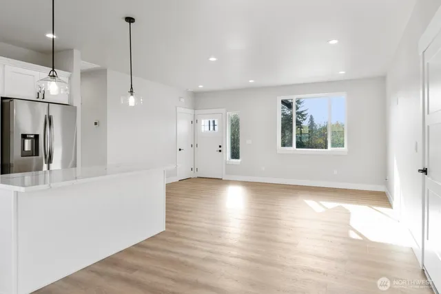 a view of empty room with wooden floor and window