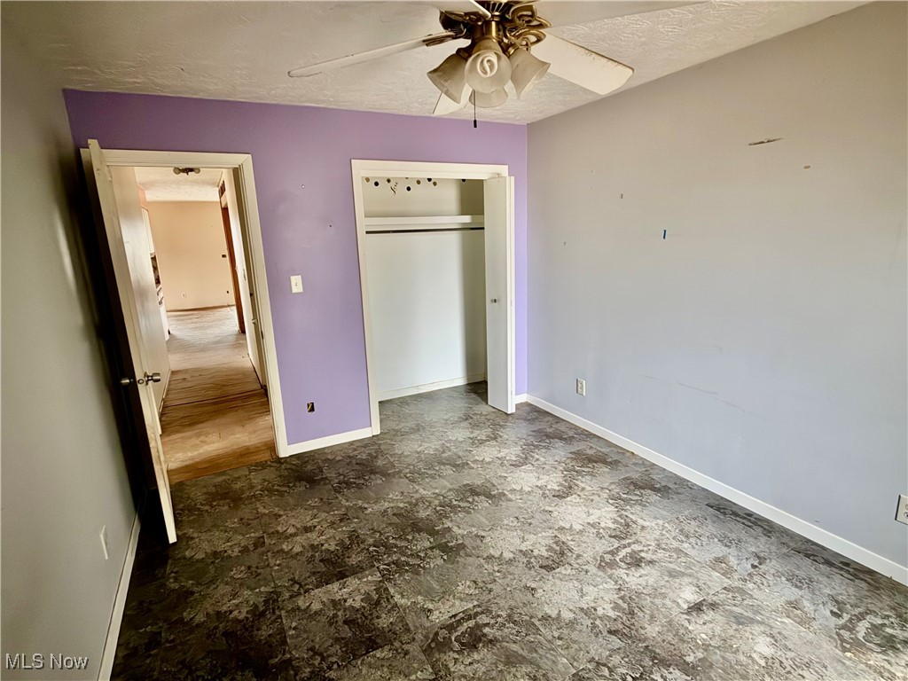 2898 Canton Road Uniontown, OH 44685 - Photo 17 of 20 Unfurnished bedroom with a closet, a textured ceiling, and ceiling fan