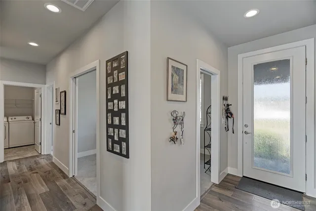 a view of a hallway with wooden floor and closet
