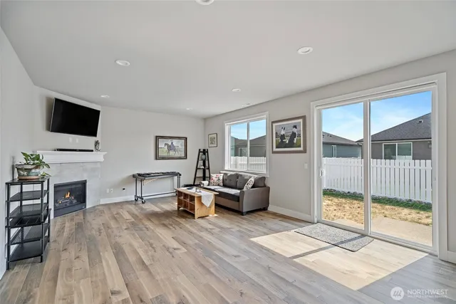 a living room with furniture a flat screen tv and a floor to ceiling window