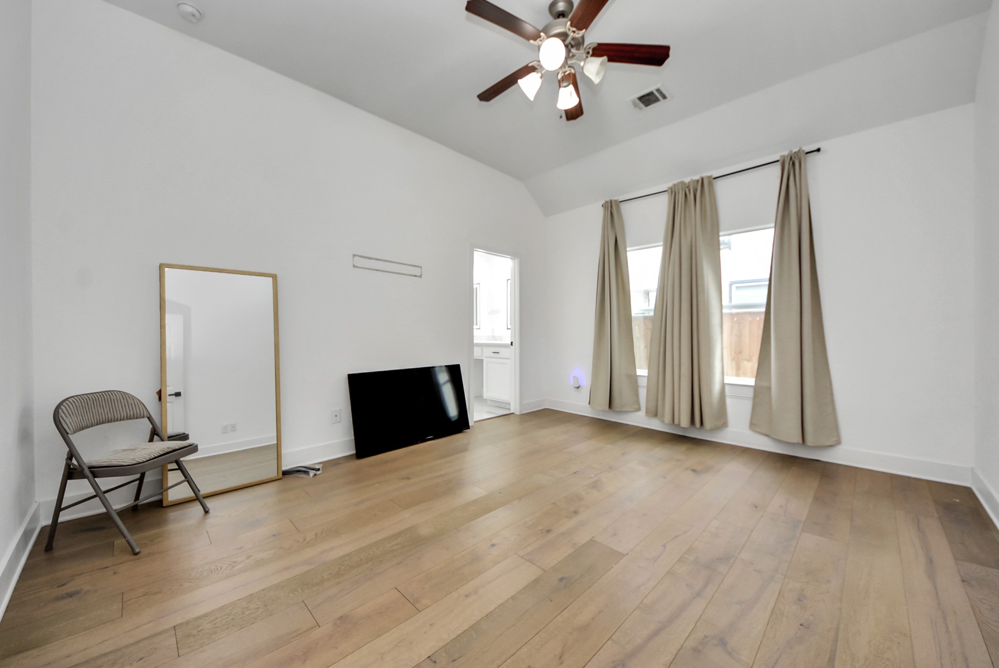 2311 Canfield Street Houston, TX 77004 - Photo 21 of 38 a view of a livingroom with a large window wooden floor and a chandelier fan