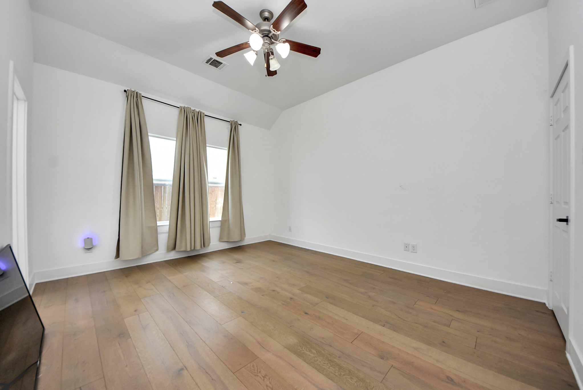 2311 Canfield Street Houston, TX 77004 - Photo 23 of 38 an empty room with wooden floor fan and windows