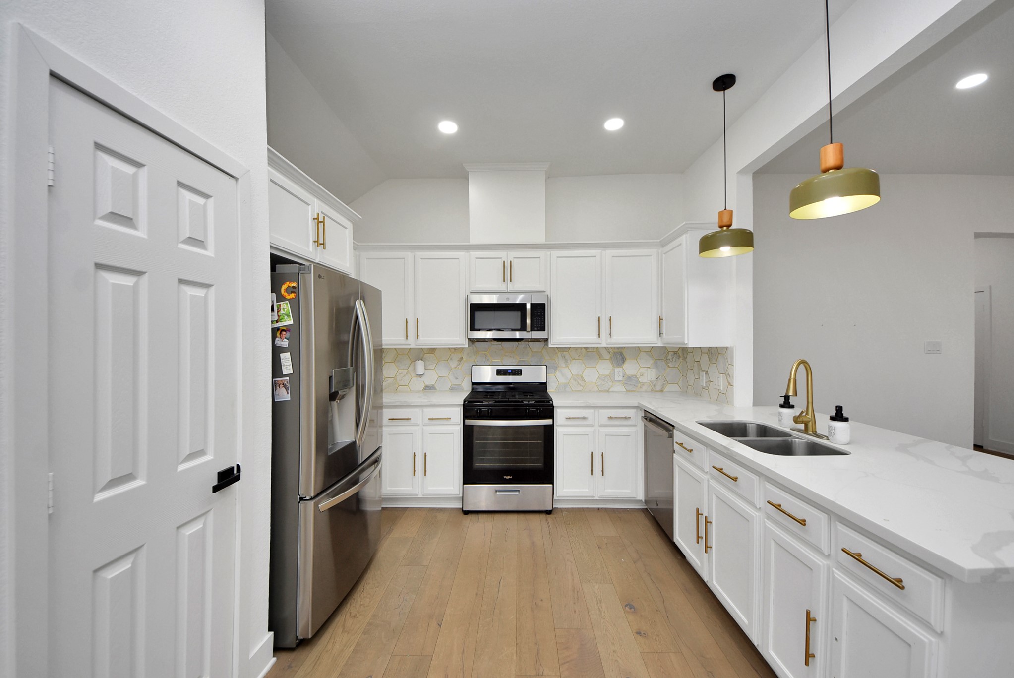 2311 Canfield Street Houston, TX 77004 - Photo 10 of 38 a kitchen with stainless steel appliances white cabinets and wooden floors