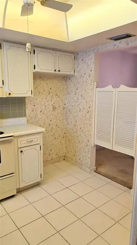 a kitchen with granite countertop cabinets sink and white appliances