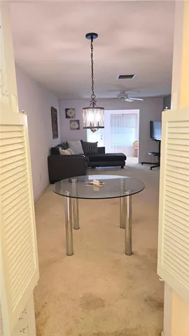 a hallway with a table and chandelier