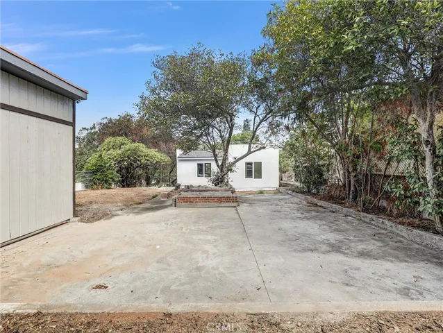 a view of a white house with a outdoor space and trees