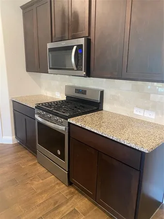 a kitchen with granite countertop cabinets stainless steel appliances and a counter space