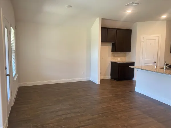 a view of kitchen with wooden floor and electronic appliances