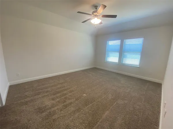an empty room with a window and a ceiling fan