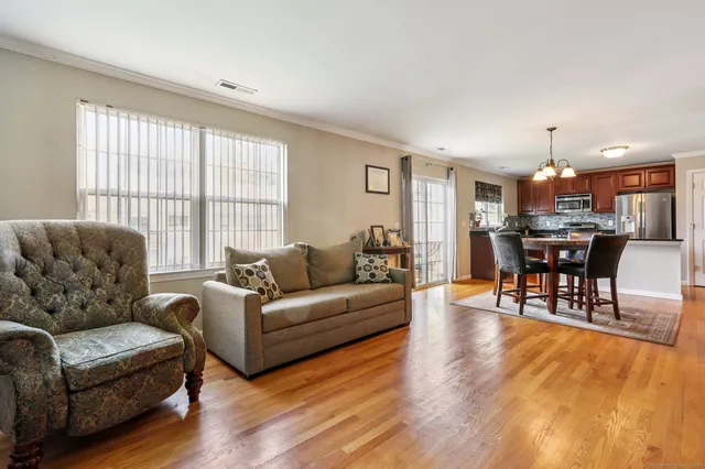 a living room with furniture a dining table and a large window