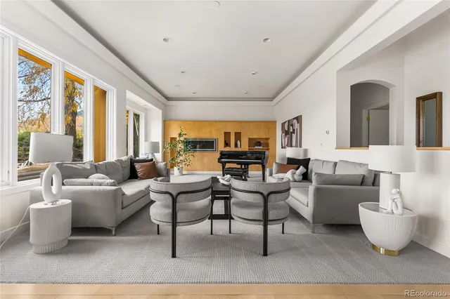 a living room with furniture a large window and a table