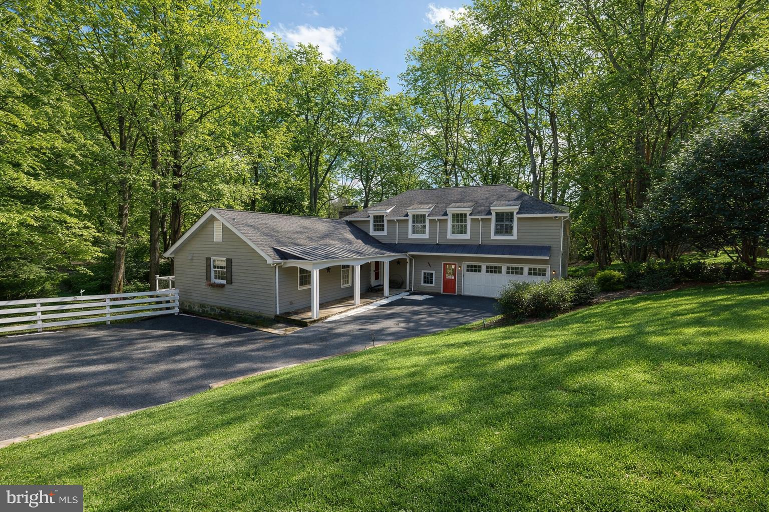 a view of a house with a big yard and large trees