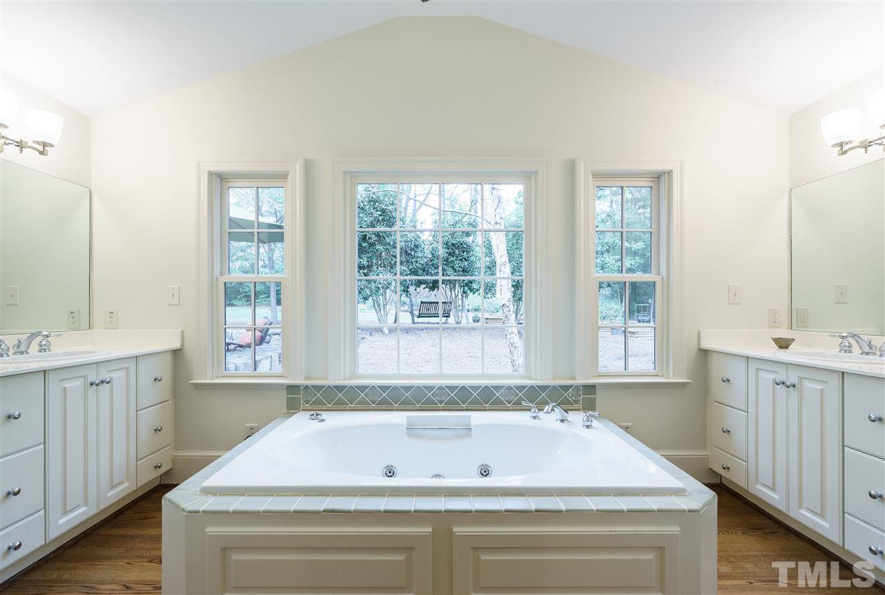 3202 Birnamwood Road Raleigh, NC 27607 - Photo 11 of 25 a bathroom with a bathtub a sink and a window
