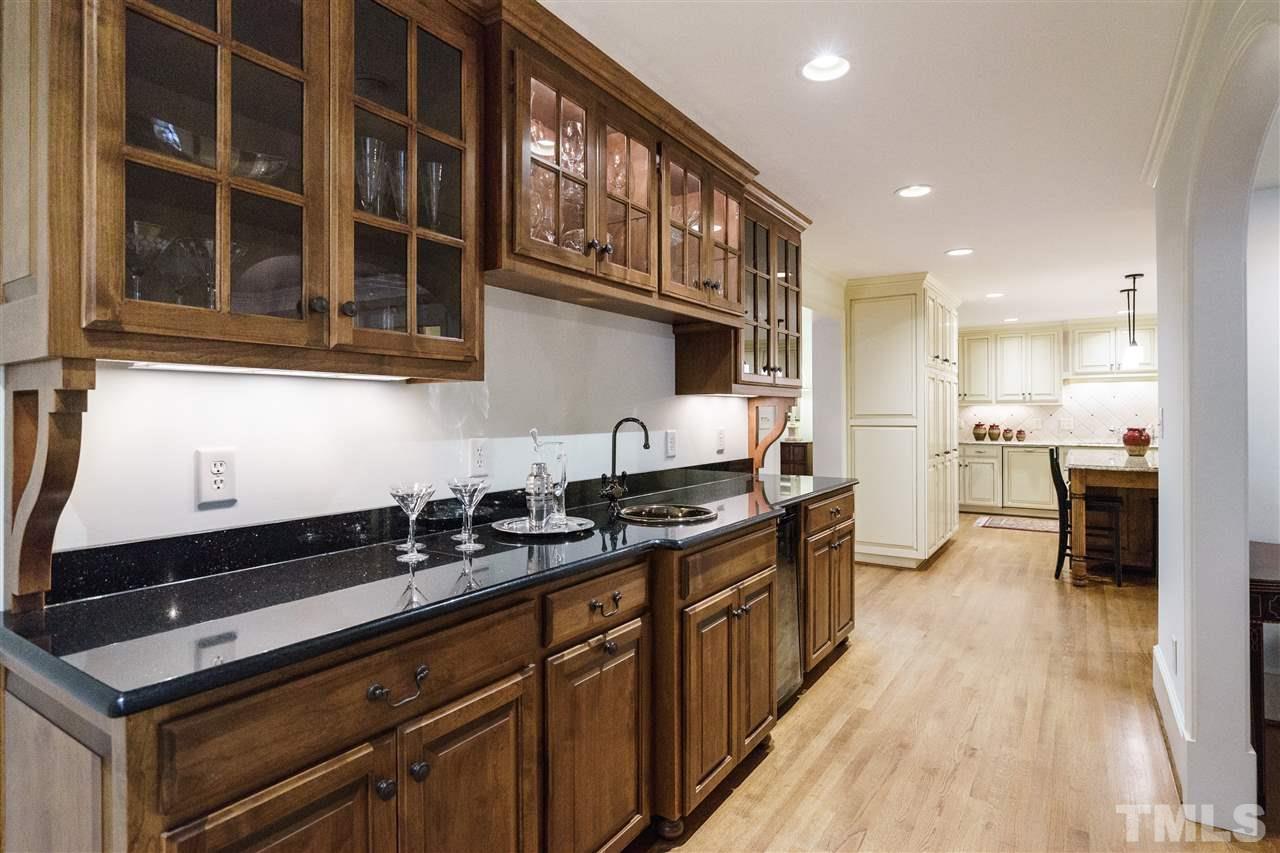 3202 Birnamwood Road Raleigh, NC 27607 - Photo 13 of 25 a kitchen with granite countertop a sink a stove and cabinets