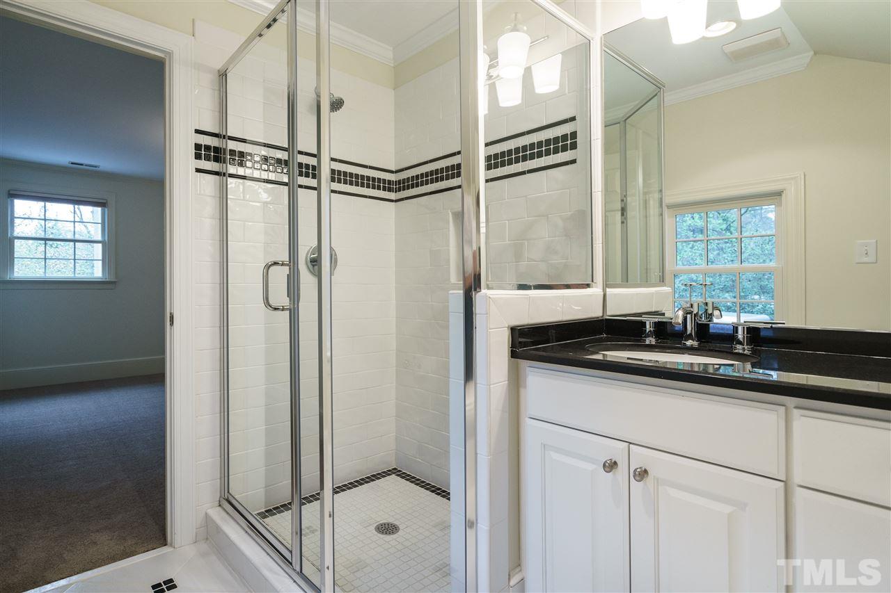 3202 Birnamwood Road Raleigh, NC 27607 - Photo 19 of 25 a bathroom with a granite countertop sink a mirror and shower