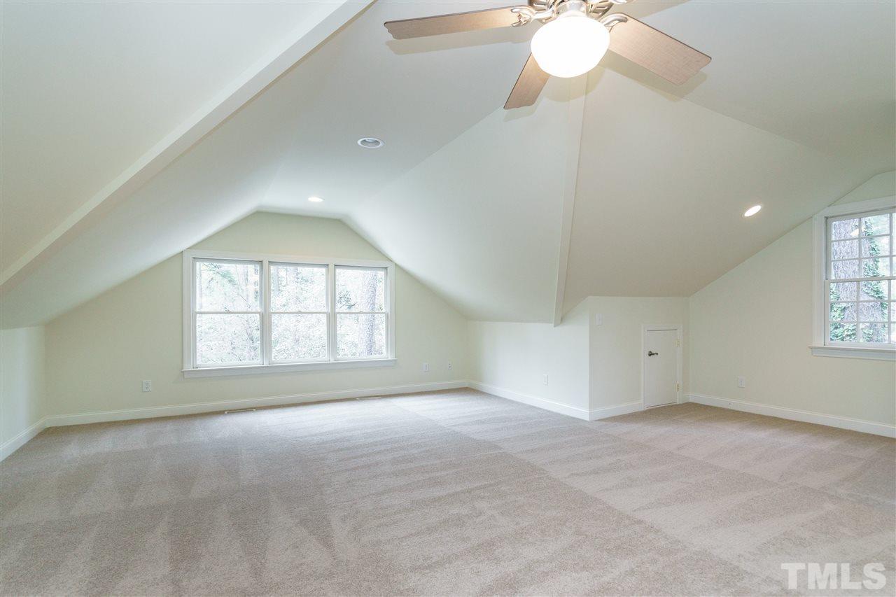3202 Birnamwood Road Raleigh, NC 27607 - Photo 21 of 25 an empty room with a chandelier fan and windows