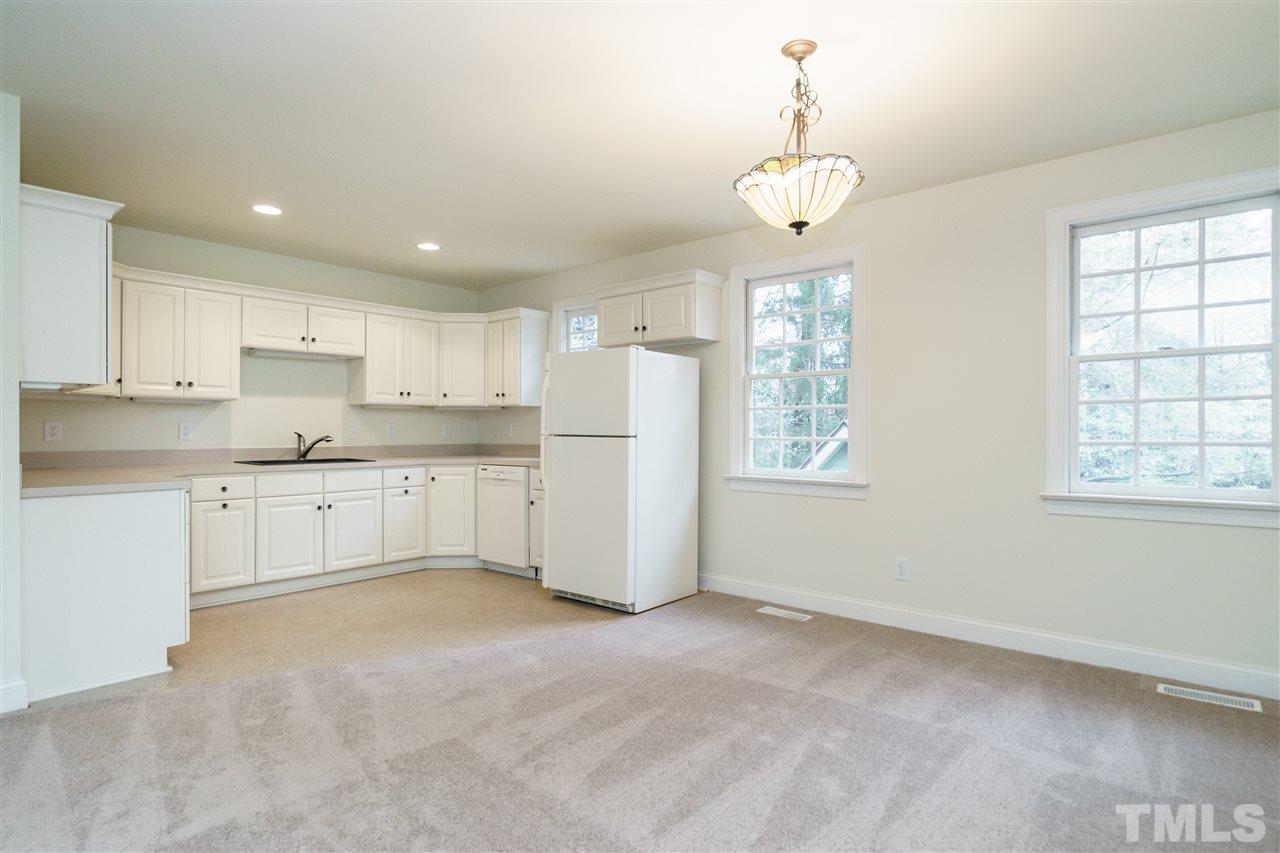 3202 Birnamwood Road Raleigh, NC 27607 - Photo 22 of 25 a open kitchen with cabinets a window and stainless steel appliances