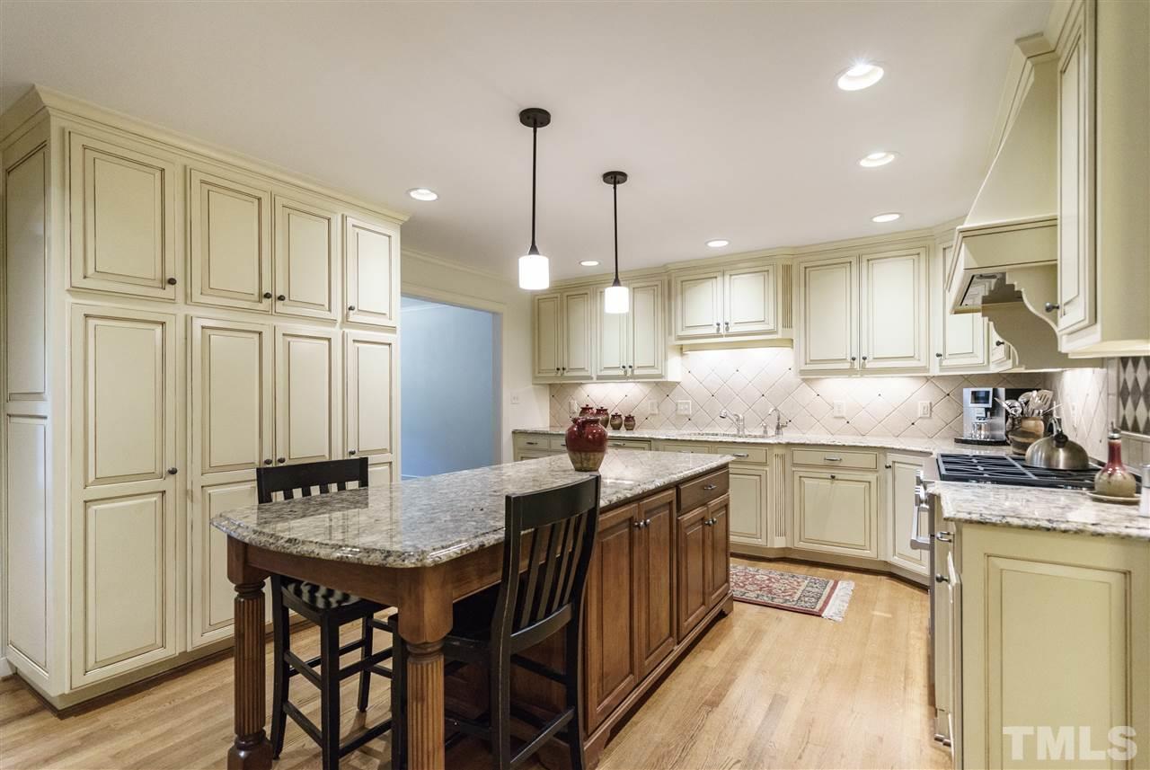 3202 Birnamwood Road Raleigh, NC 27607 - Photo 6 of 25 a kitchen with granite countertop a sink a center island stainless steel appliances and cabinets