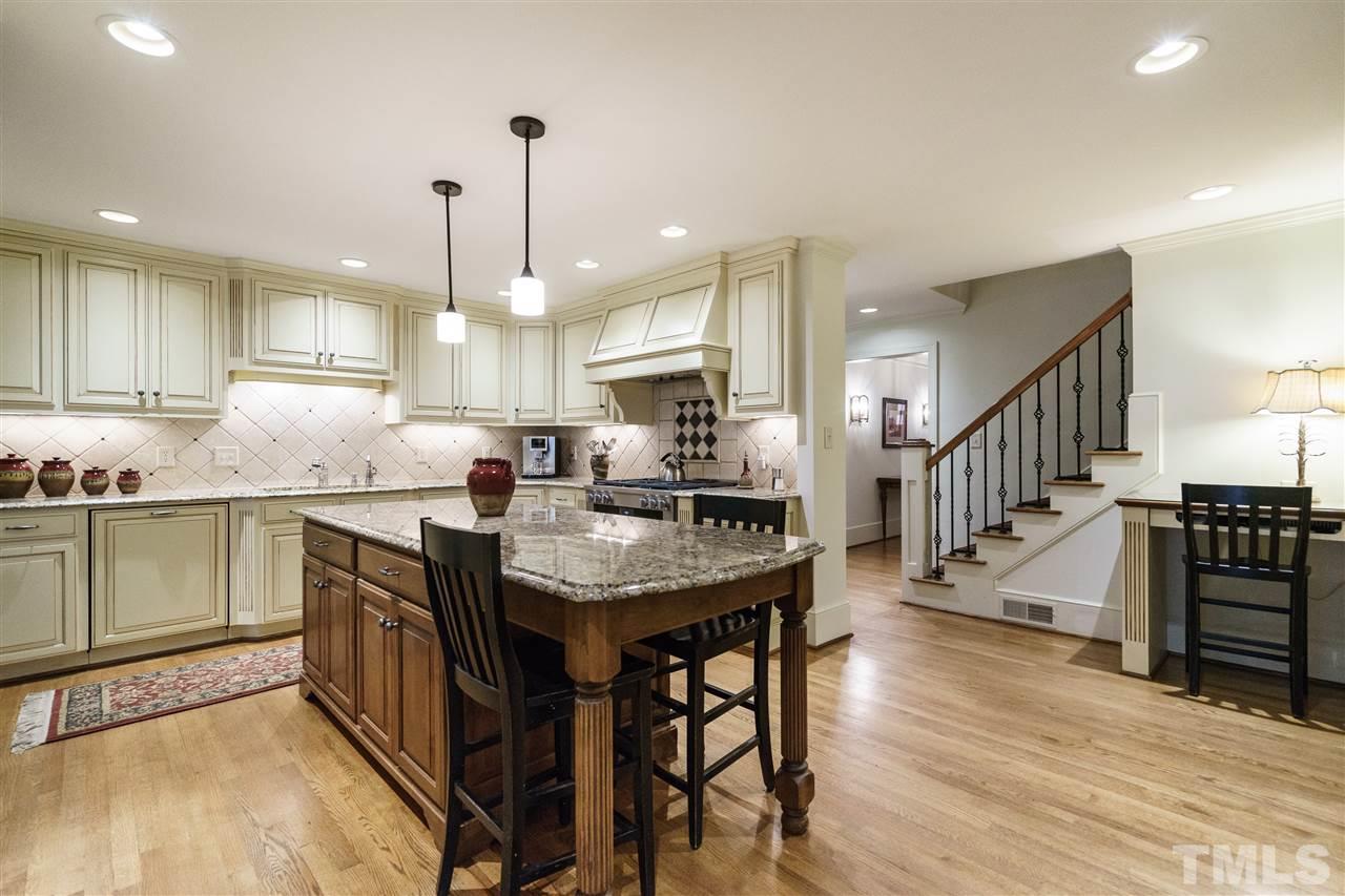 3202 Birnamwood Road Raleigh, NC 27607 - Photo 7 of 25 a kitchen with granite countertop a table chairs stove a sink and a refrigerator