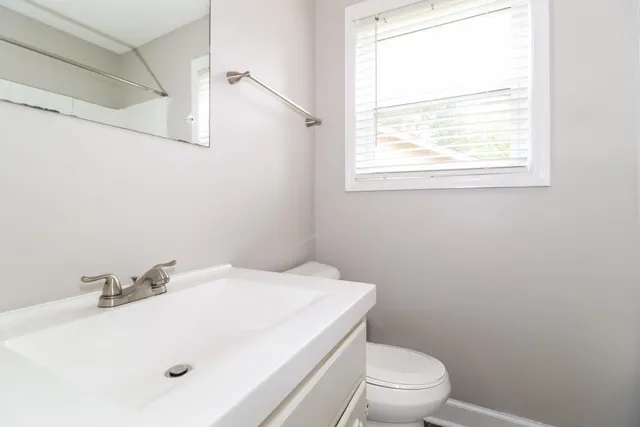 a bathroom with a sink a toilet and a window