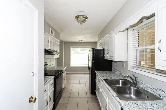 a kitchen with a sink and a refrigerator