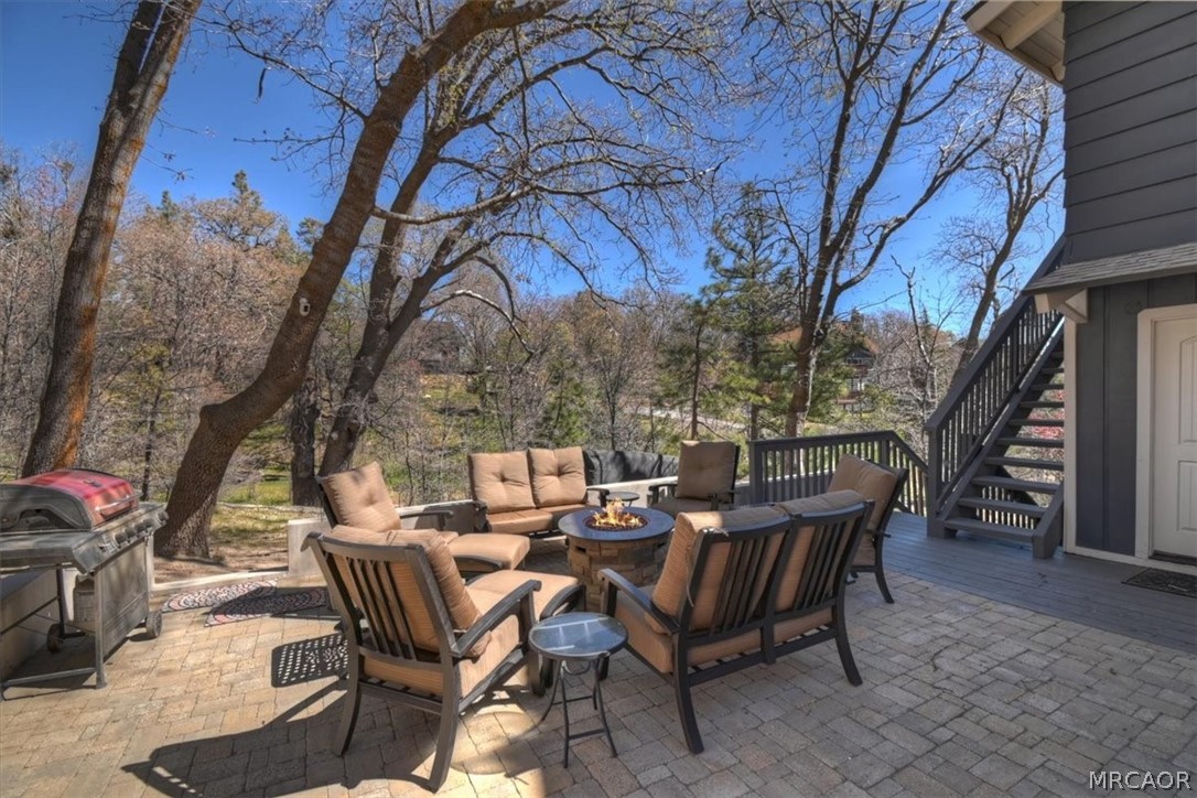 27994 West Shore Road Lake Arrowhead, CA 92352 - Photo 25 of 30 a view of a patio with table and chairs and floor to ceiling window