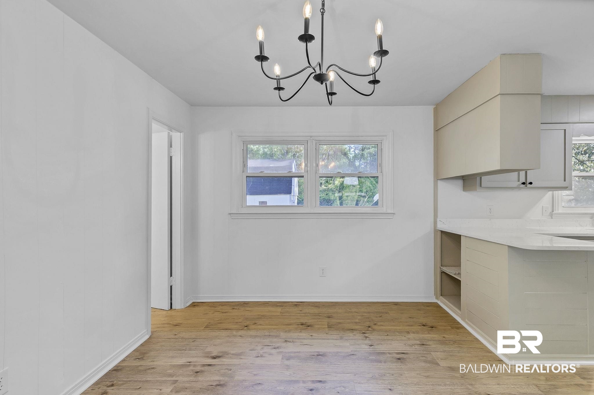 203 Anderson Road Saraland, AL 36571 - Photo 12 of 48 Unfurnished dining area with a chandelier, light wood-type flooring, a healthy amount of sunlight, and baseboards