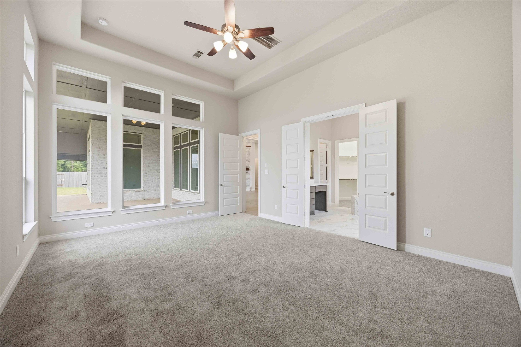 17564 Watercolor Way Conroe, TX 77302 - Photo 21 of 42 Primary bedroom with floor to ceiling windows and sweeping views of the lush backyard