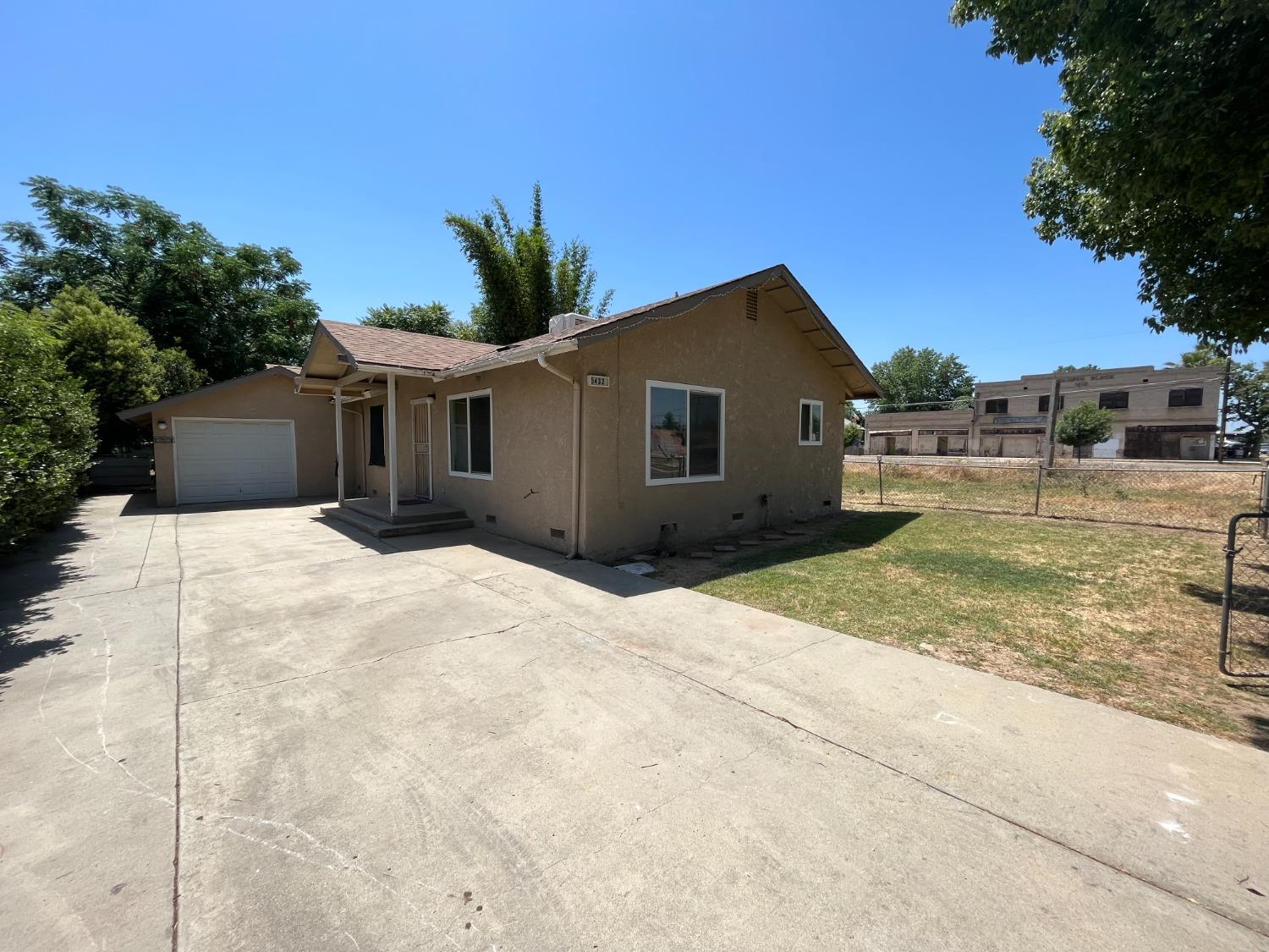 5433 Wildwood Del Rey, CA 93616 - Photo 16 of 17 a front view of a house with a yard and garage