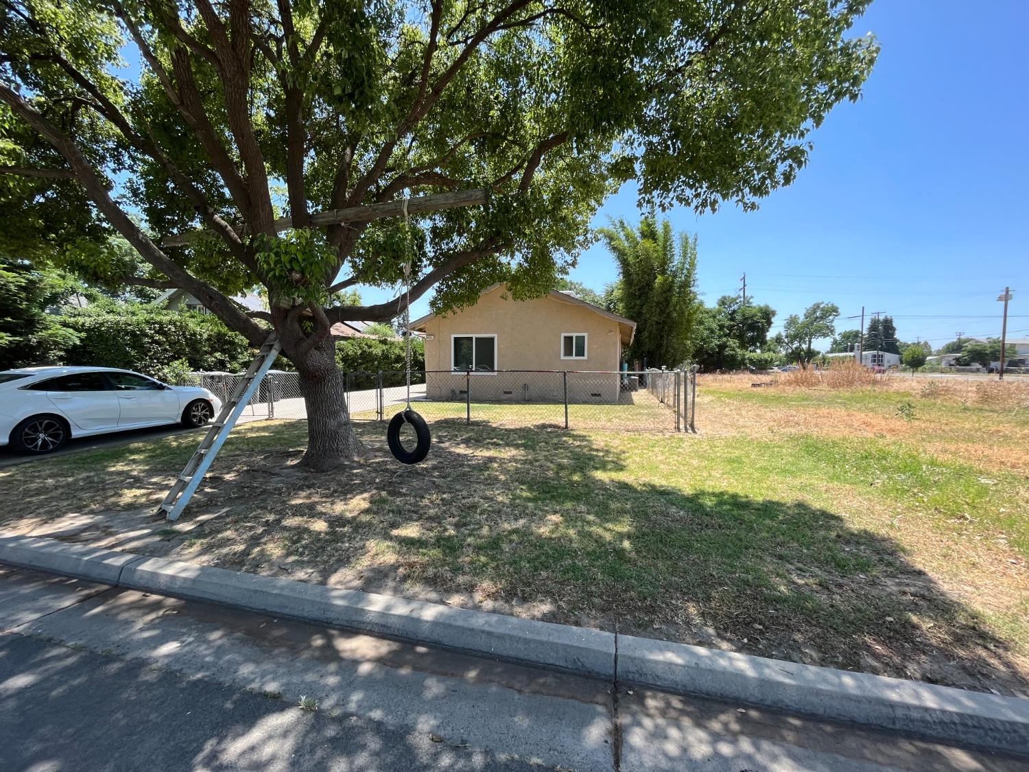 5433 Wildwood Del Rey, CA 93616 - Photo 2 of 17 a front view of a house with a yard and garage