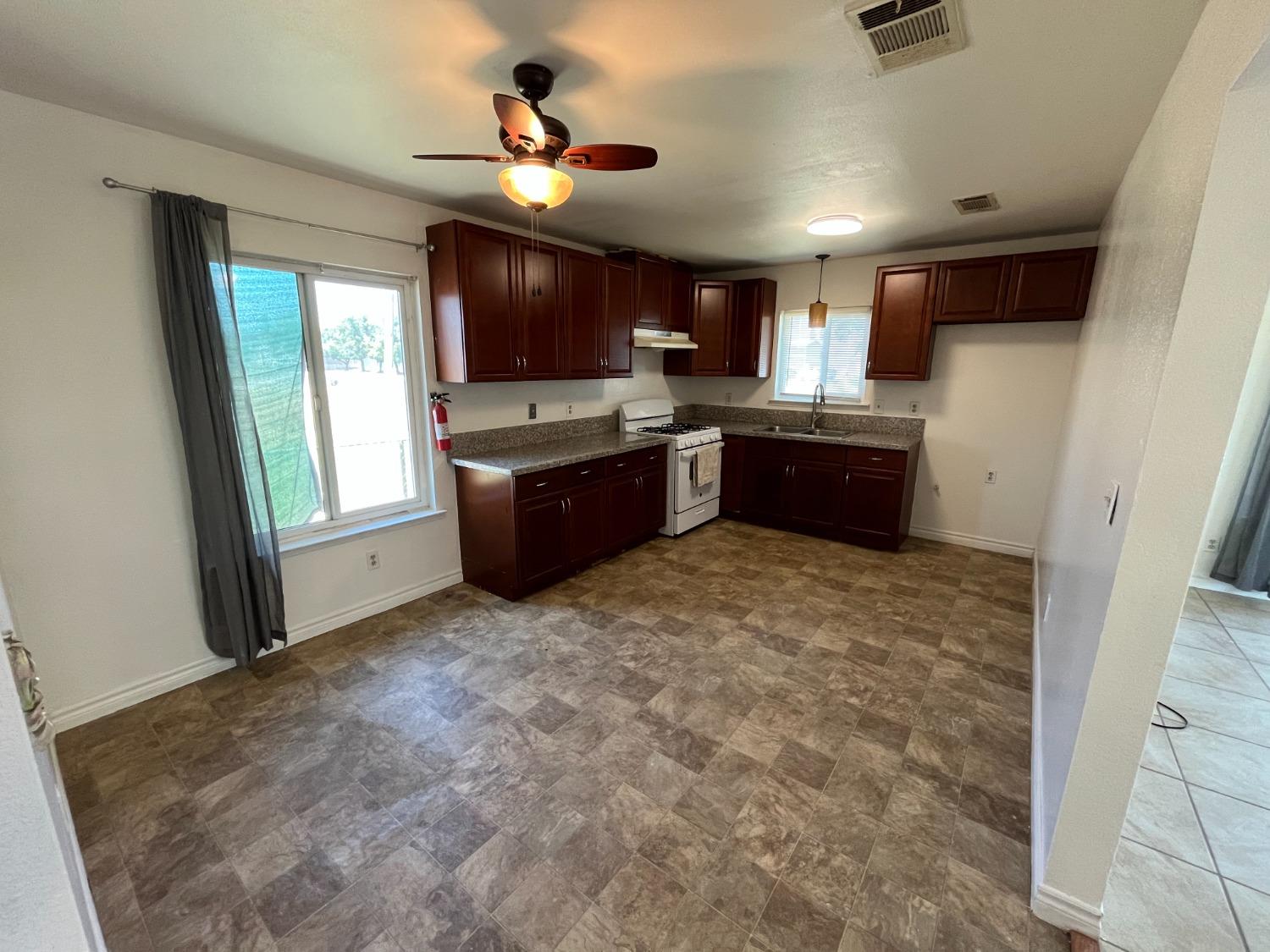 5433 Wildwood Del Rey, CA 93616 - Photo 4 of 17 a large kitchen with a window and stainless steel appliances