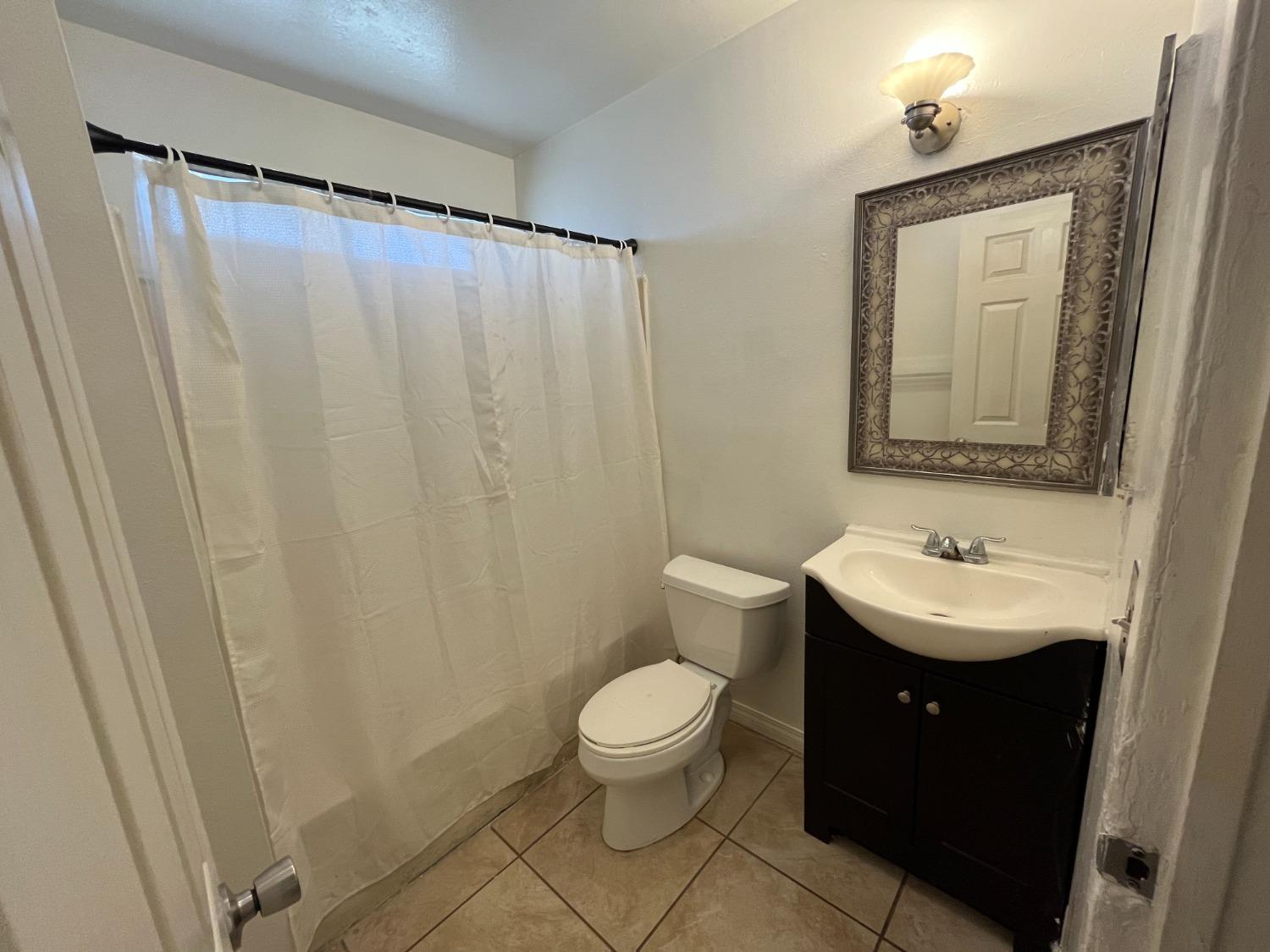 5433 Wildwood Del Rey, CA 93616 - Photo 5 of 17 a bathroom with a sink a toilet and a mirror