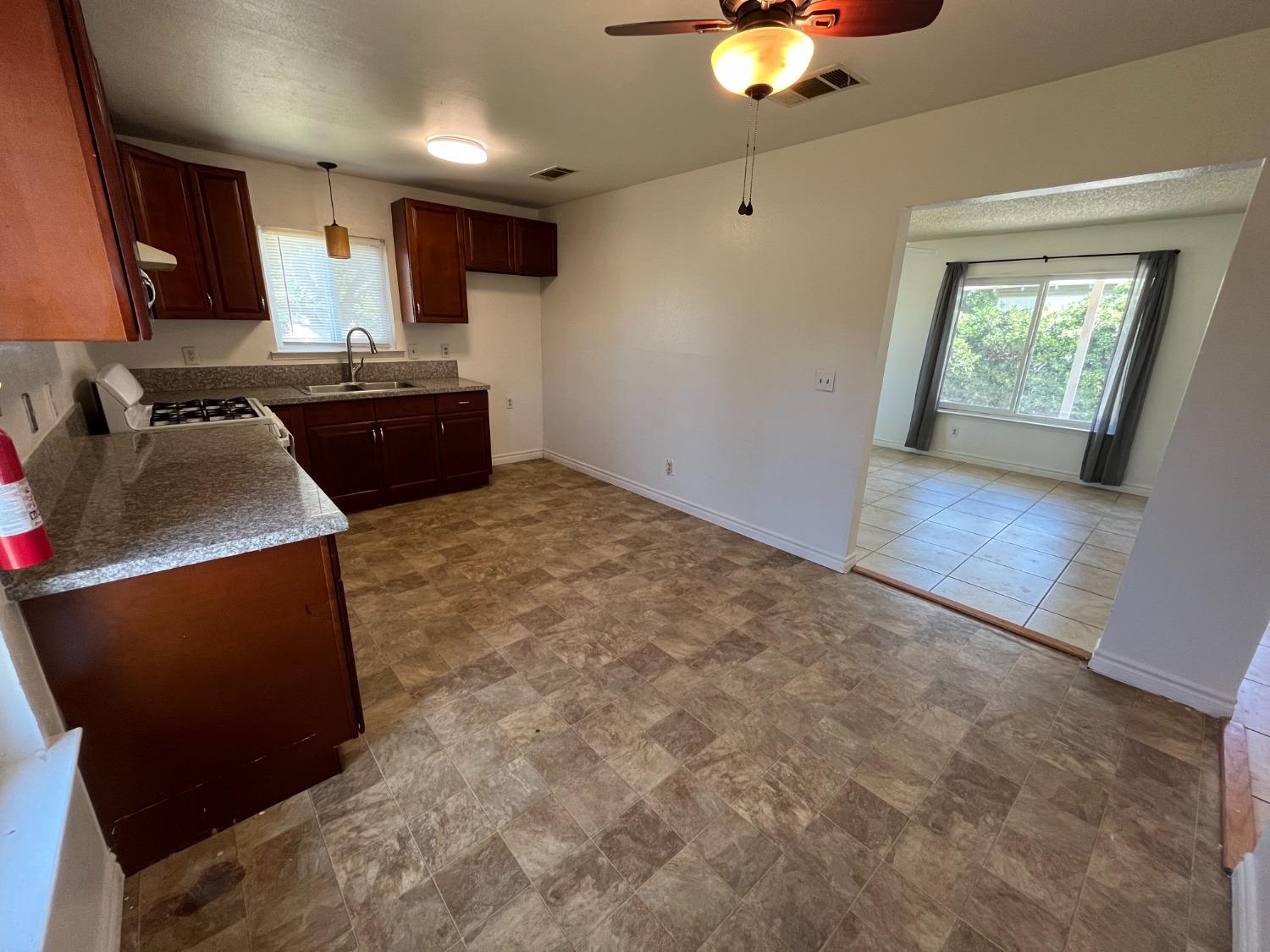 5433 Wildwood Del Rey, CA 93616 - Photo 8 of 17 a kitchen with stainless steel appliances granite countertop a stove a sink and a refrigerator
