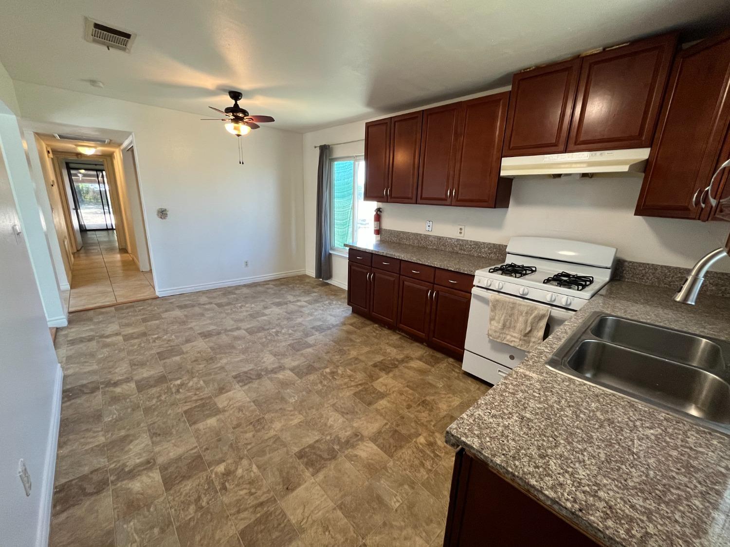 5433 Wildwood Del Rey, CA 93616 - Photo 9 of 17 a kitchen with granite countertop a stove refrigerator and microwave