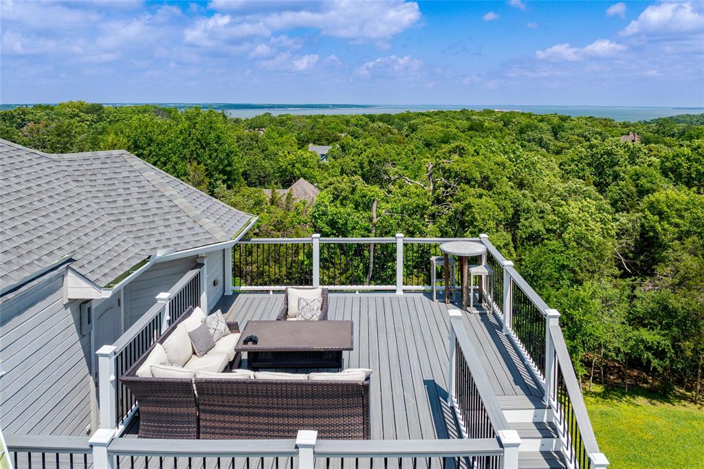 a roof deck with wooden floor and fence