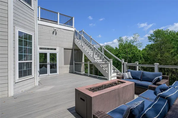 a view of a deck with couches with wooden floor and fence