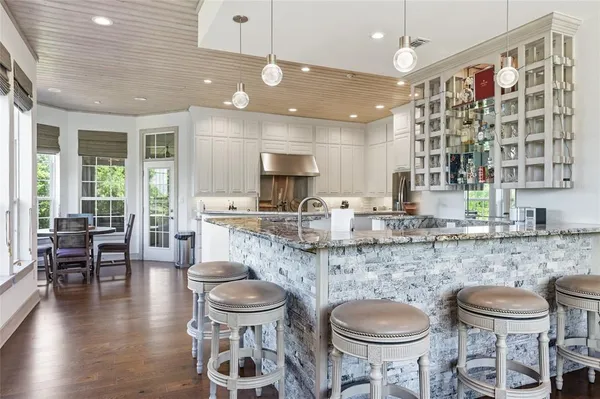 a large kitchen with kitchen island a dining table and chairs