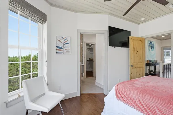 a bed room with a bed a television and a window