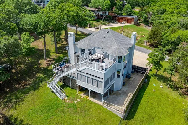 an aerial view of a house with swimming pool and large trees
